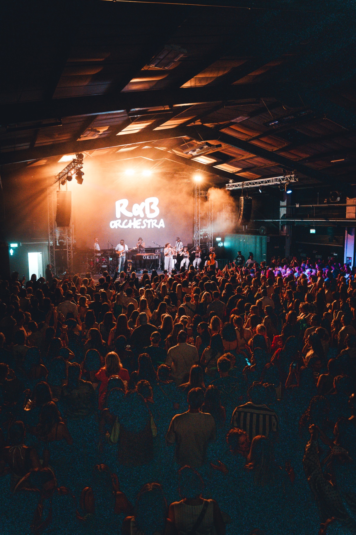 Band on stage facing a full crowd